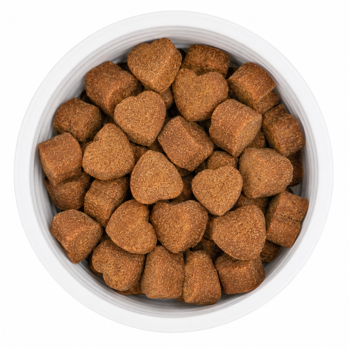 Heart-shaped brown pet chew pieces piled in a white bowl on a white background.